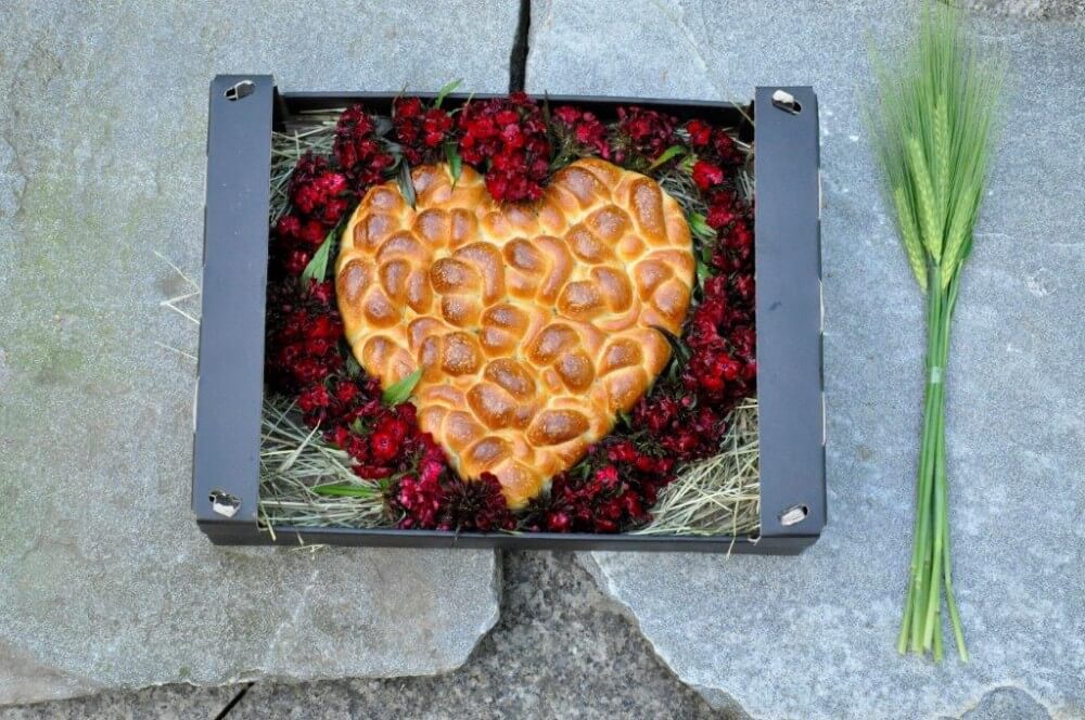 Ein schön angerichtetes Brot für eine Hochzeit in Herzform aus dem Holzofen vom Hof Riedweid Hofladen.